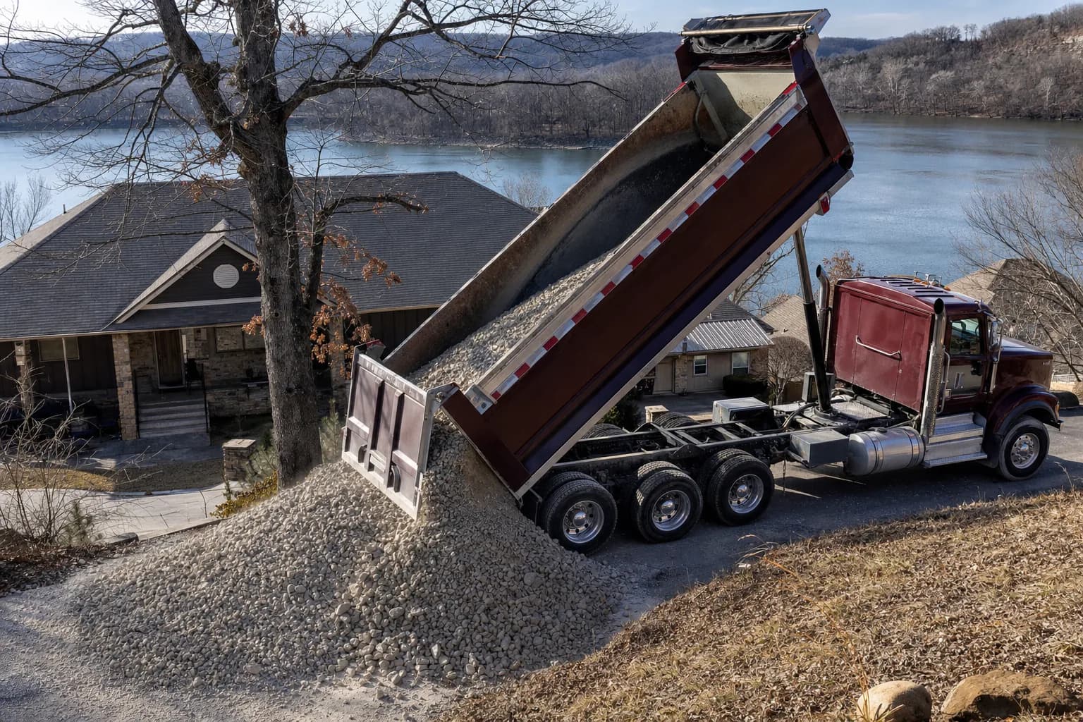 Dump truck delivering gravel to a residential property